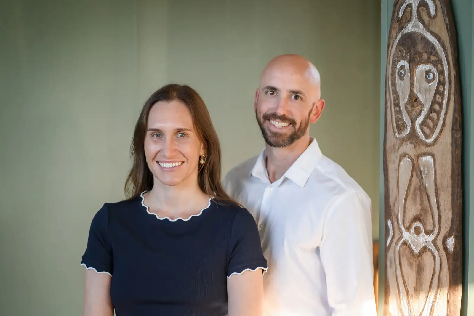 Two Grove Support Services support workers standing together in a warm, naturally lit consulting room