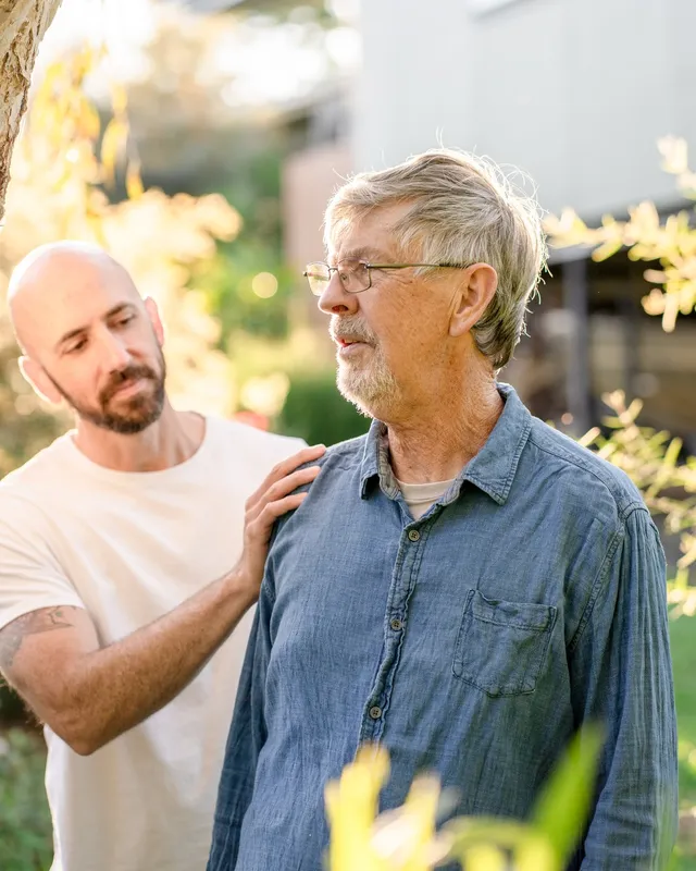 A support worker and an older man together outdoors